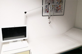 EKG - Elektrokardiogramm Computer sowie EKG- Elektroden und die Ruheliege für das Ruhe-EKG